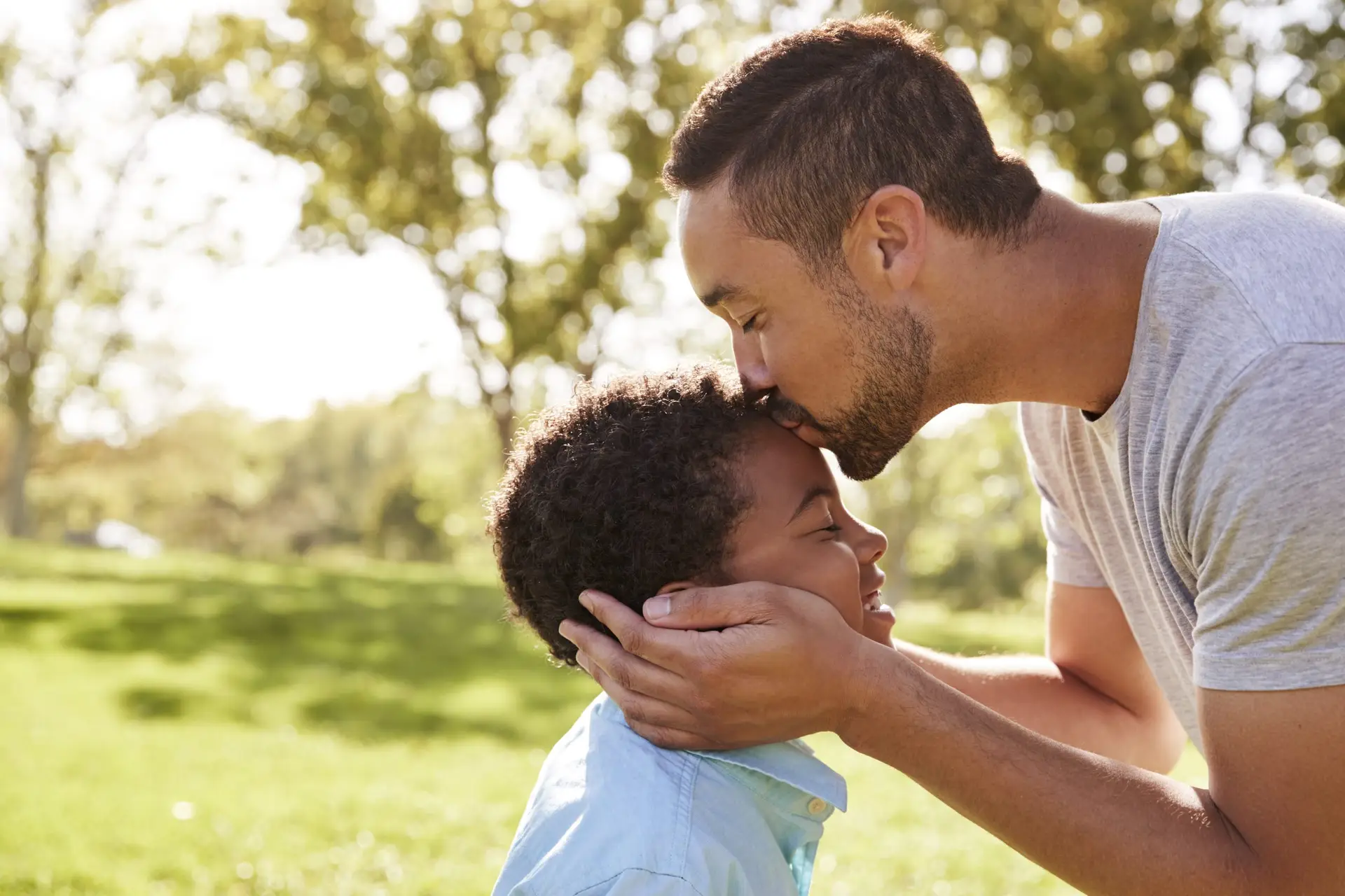 Close Up Of Father Kissing Son In Park