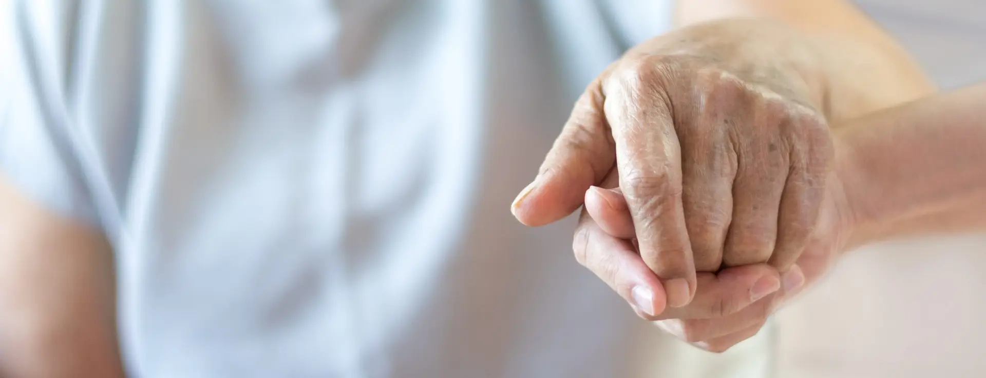 Caregiver, carer hand holding elder hand in hospice care background. Philanthropy kindness to disabled old people concept.Happy mother's day.